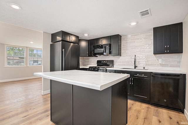 822 W Donaldson Ave, Mishawaka, IN 46545 - kitchen featuring black appliances, light countertops, decorative backsplash, and a kitchen island