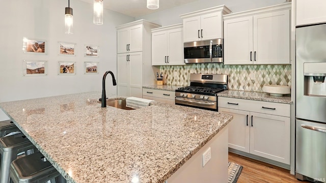 420 Catherwood Dr Unit 3, West Lafayette, IN 47906 - kitchen with stainless steel appliances, backsplash, a breakfast bar, light stone countertops, and light wood-style floors