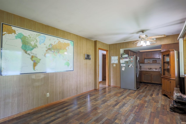335 E State Road 58, Bedford, IN 47421 - kitchen featuring freestanding refrigerator, dark wood-type flooring, wood walls, and ceiling fan