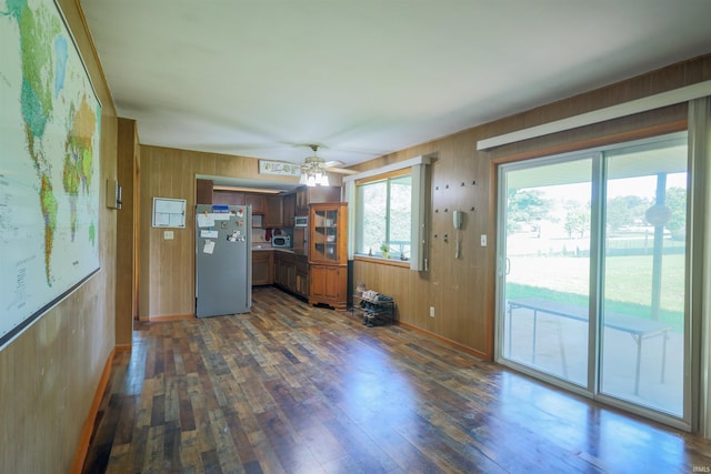 335 E State Road 58, Bedford, IN 47421 - kitchen with freestanding refrigerator, wooden walls, dark wood finished floors, a ceiling fan, and brown cabinets