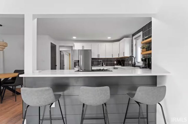 52354 Forestbrook Ave, South Bend, IN 46637 - kitchen with appliances with stainless steel finishes, a peninsula, a breakfast bar area, white cabinetry, and recessed lighting
