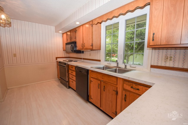 3209 E Kendall Ln, Muncie, IN 47303 - kitchen featuring black appliances, wallpapered walls, light countertops, light wood-style flooring, and brown cabinetry