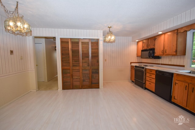 3209 E Kendall Ln, Muncie, IN 47303 - kitchen featuring a chandelier, black appliances, wallpapered walls, light wood-style floors, and light countertops
