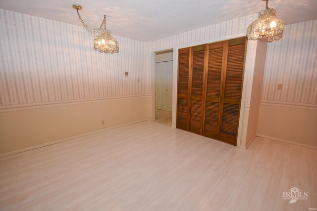 3209 E Kendall Ln, Muncie, IN 47303 - unfurnished dining area featuring a chandelier, wallpapered walls, and wood finished floors