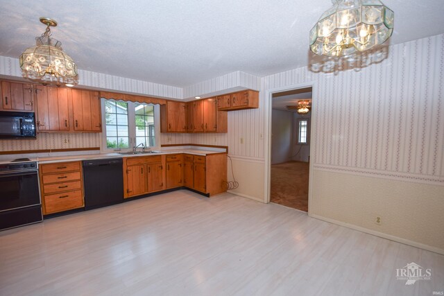 3209 E Kendall Ln, Muncie, IN 47303 - kitchen featuring black appliances, a chandelier, brown cabinets, light wood-type flooring, and light countertops