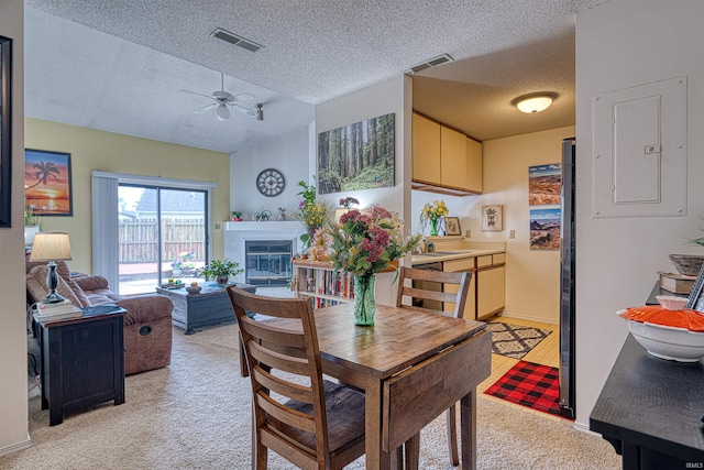 5813 Polo Run, Evansville, IN 47715 - dining area featuring light colored carpet, a textured ceiling, a glass covered fireplace, a ceiling fan, and electric panel
