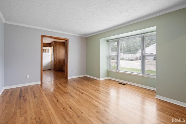 2222 S Indiana Ave, Kokomo, IN 46902 - spare room featuring a textured ceiling, light wood-style floors, and ornamental molding