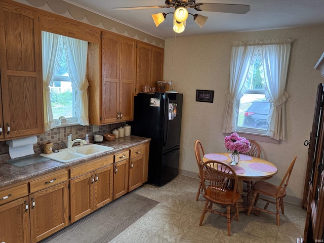 306 W Rochester St, Akron, IN 46910 - kitchen featuring freestanding refrigerator, brown cabinets, ceiling fan, light floors, and decorative backsplash
