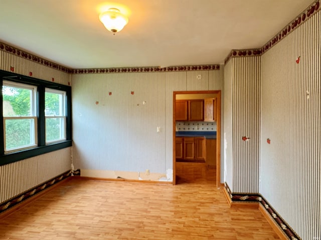 203 E Church St, Milroy, IN 46156 - empty room with wallpapered walls and light wood-style flooring