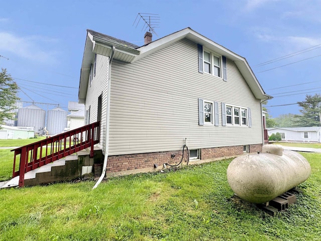 203 E Church St, Milroy, IN 46156 - view of side of property featuring a lawn and a chimney