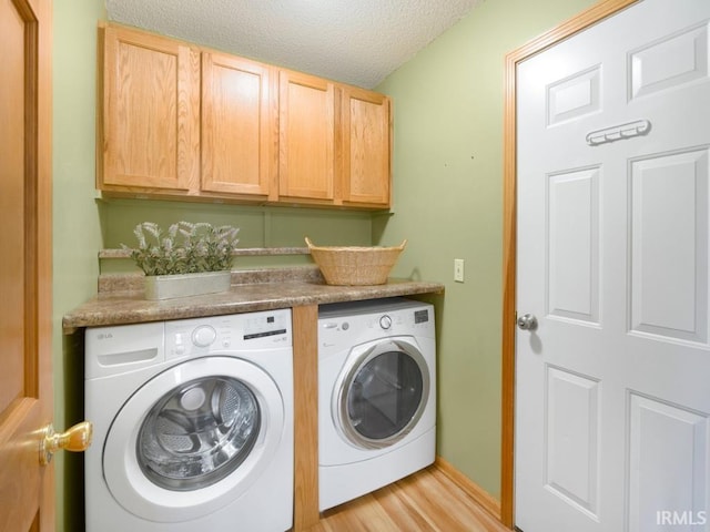 2133 Blue Harbor Dr, Fort Wayne, IN 46804 - washroom featuring independent washer and dryer, cabinet space, a textured ceiling, and light wood-type flooring