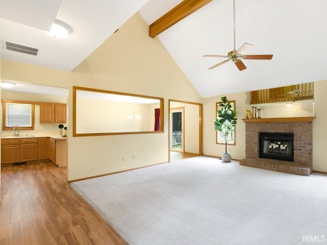 2133 Blue Harbor Dr, Fort Wayne, IN 46804 - unfurnished living room featuring high vaulted ceiling, ceiling fan, light wood-style flooring, beam ceiling, and a brick fireplace