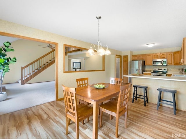 2133 Blue Harbor Dr, Fort Wayne, IN 46804 - dining space featuring light wood-style floors, stairs, and a chandelier