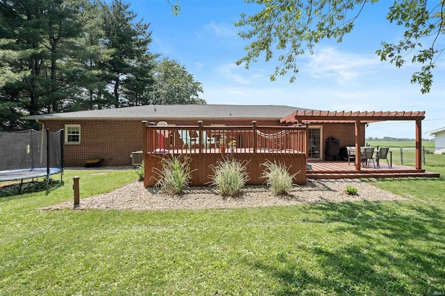 3076 N 450 Rd E, Logansport, IN 46947 - back of house featuring a trampoline, a pergola, brick siding, a deck, and a yard