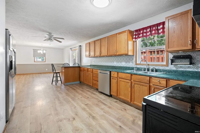 3076 N 450 Rd E, Logansport, IN 46947 - kitchen featuring stainless steel appliances, a textured ceiling, light wood-style floors, a peninsula, and decorative backsplash