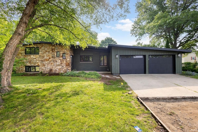 5228 N Lee Ct, South Bend, IN 46614 - view of front facade featuring driveway, a garage, a front lawn, and stone siding