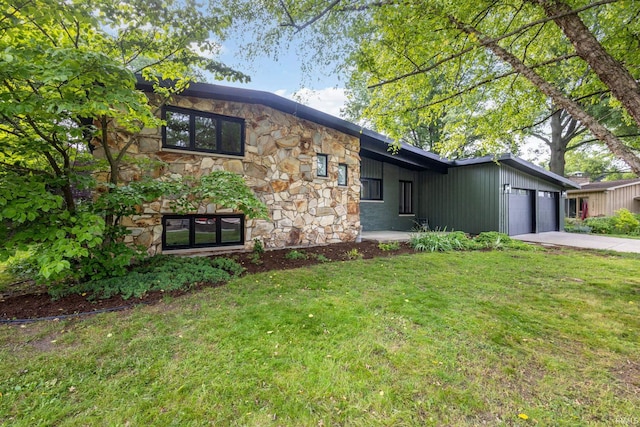 5228 N Lee Ct, South Bend, IN 46614 - mid-century home featuring stone siding, an attached garage, a front yard, and driveway