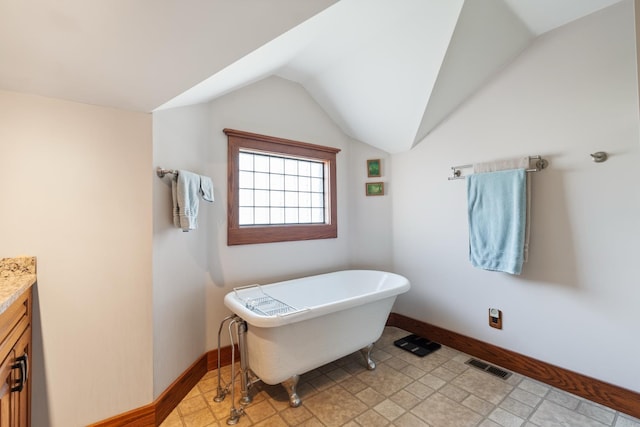 1791 Chapman Lake Dr, Warsaw, IN 46582 - bathroom with vanity, a freestanding bath, and lofted ceiling
