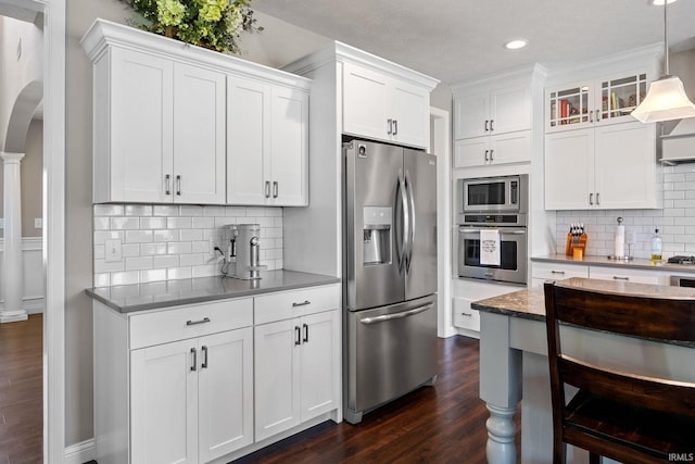 1869 Paloma Ct, Lafayette, IN 47909 - kitchen featuring stainless steel appliances, dark wood finished floors, arched walkways, white cabinets, and decorative backsplash