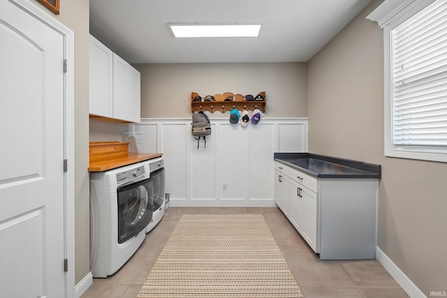 1869 Paloma Ct, Lafayette, IN 47909 - laundry area featuring washing machine and dryer, cabinet space, wainscoting, light tile patterned flooring, and healthy amount of natural light