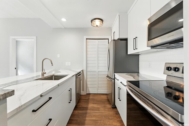 112 W Washington Blvd Unit 329, Fort Wayne, IN 46802 - kitchen featuring appliances with stainless steel finishes, dark wood finished floors, light stone countertops, decorative backsplash, and white cabinetry