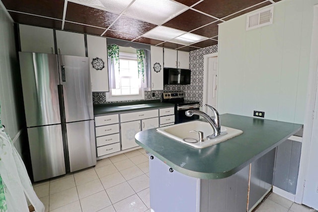 2907 Prairie Ln, Lafayette, IN 47904 - kitchen featuring stainless steel appliances, dark countertops, light tile patterned floors, decorative backsplash, and white cabinets