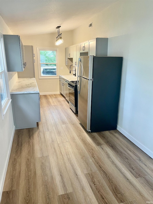 210 Gladstone Dr, Wabash, IN 46992 - kitchen with freestanding refrigerator, light countertops, light wood-style floors, and black gas range oven