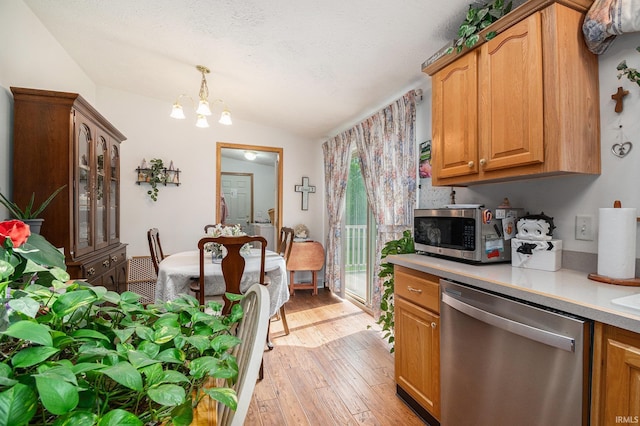 205 Par Blvd, Bristol, IN 46507 - kitchen with appliances with stainless steel finishes, lofted ceiling, light countertops, light wood-style flooring, and a chandelier