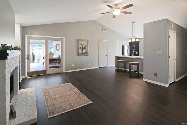 3847 Lodi Ln, Lafayette, IN 47905 - living room featuring vaulted ceiling, ceiling fan, dark wood-type flooring, and a brick fireplace