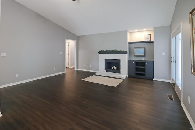 3847 Lodi Ln, Lafayette, IN 47905 - unfurnished living room with vaulted ceiling, a brick fireplace, and dark wood-style flooring
