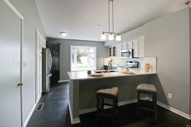 3847 Lodi Ln, Lafayette, IN 47905 - kitchen with appliances with stainless steel finishes, glass insert cabinets, a peninsula, a breakfast bar, and decorative backsplash