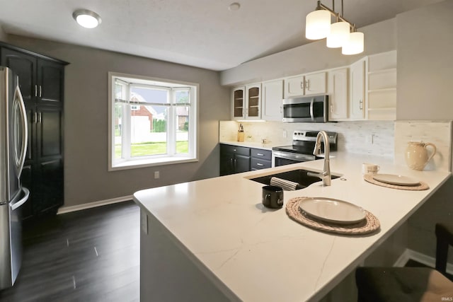 3847 Lodi Ln, Lafayette, IN 47905 - kitchen featuring stainless steel appliances, decorative backsplash, a peninsula, and glass insert cabinets