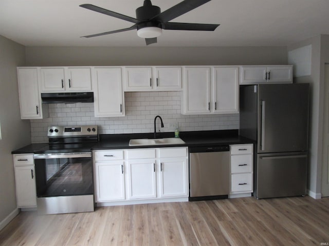 2305 Hillis Ct, Kokomo, IN 46902 - kitchen with stainless steel appliances, under cabinet range hood, dark countertops, a ceiling fan, and light wood-type flooring