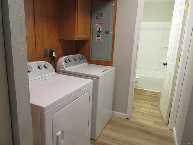 2305 Hillis Ct, Kokomo, IN 46902 - laundry area featuring washing machine and dryer, light wood finished floors, electric panel, and cabinet space