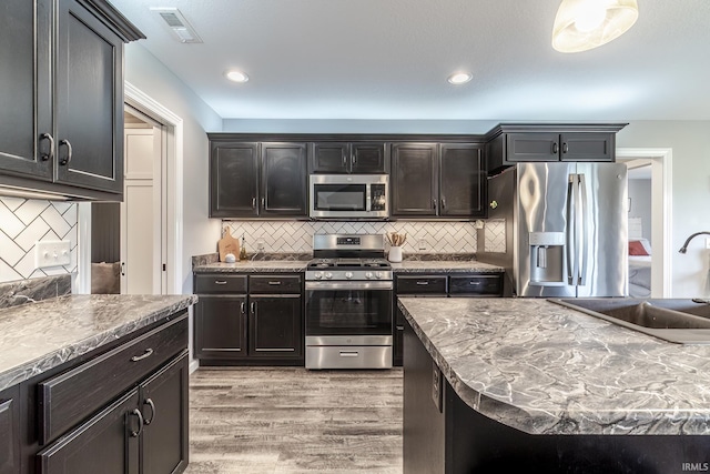 1492 Monte Carlo Dr, Huntertown, IN 46748 - kitchen featuring stainless steel appliances, light wood-style floors, tasteful backsplash, and recessed lighting