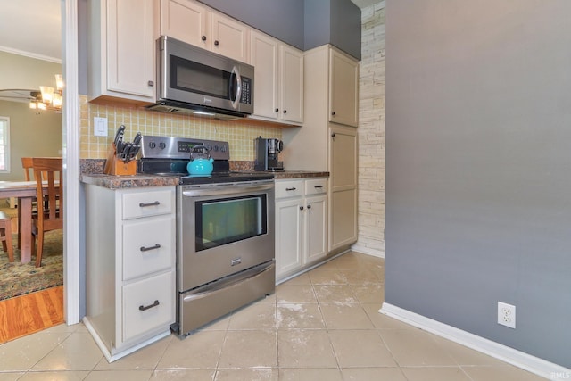 2736 Marion Ave, Evansville, IN 47712 - kitchen with appliances with stainless steel finishes, dark countertops, light tile patterned flooring, decorative backsplash, and crown molding