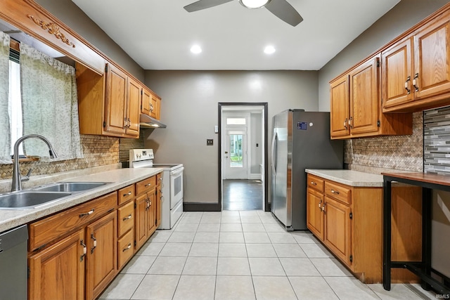 1015 Columbia Ave, Fort Wayne, IN 46805 - kitchen featuring stainless steel appliances, light countertops, ceiling fan, backsplash, and under cabinet range hood