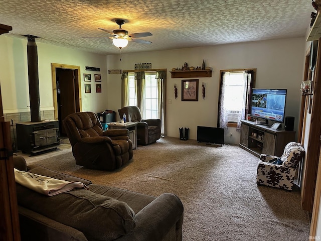 13687 E Ivan Ct, Bloomington, IN 47403 - living room with a wood stove, a ceiling fan, healthy amount of natural light, carpet floors, and a textured ceiling
