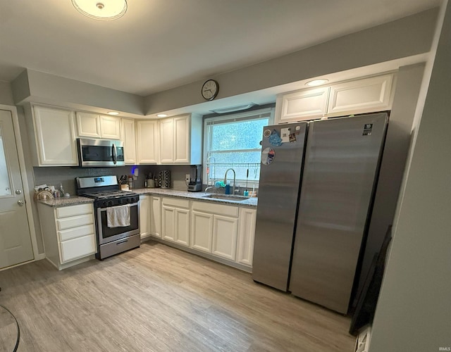 1814 S Douglas St, South Bend, IN 46613 - kitchen featuring appliances with stainless steel finishes, light wood-style flooring, white cabinetry, and light stone countertops