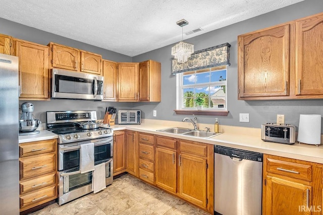 3317 Jacob Pl, Lafayette, IN 47909 - kitchen with stainless steel appliances, light countertops, a chandelier, a textured ceiling, and hanging light fixtures