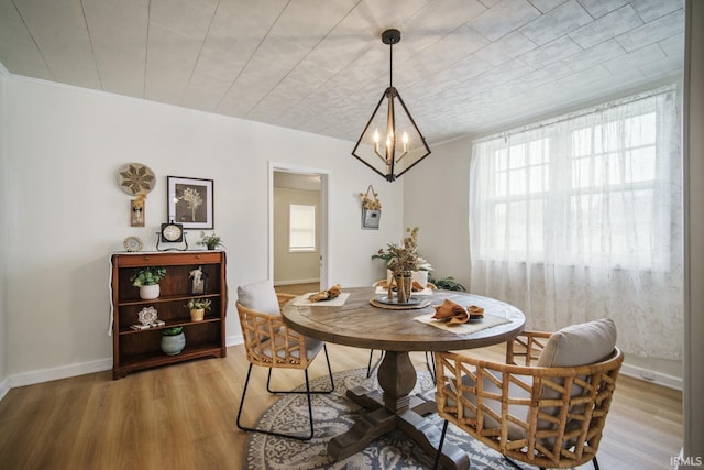 701 E N St, Kokomo, IN 46901 - dining room featuring plenty of natural light, light wood-type flooring, a chandelier, and crown molding