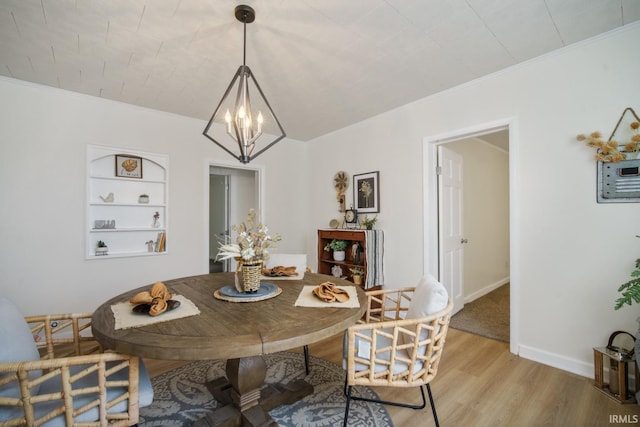 701 E N St, Kokomo, IN 46901 - dining space with a chandelier, light wood-style flooring, crown molding, and built in shelves