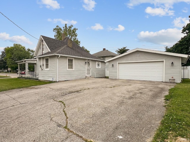 701 E N St, Kokomo, IN 46901 - view of front of home with a detached garage, a front yard, and roof with shingles