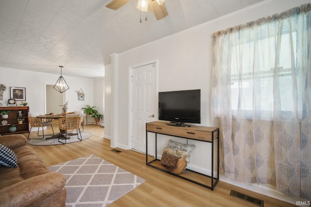 701 E N St, Kokomo, IN 46901 - living area featuring wood finished floors, ceiling fan, crown molding, and a chandelier