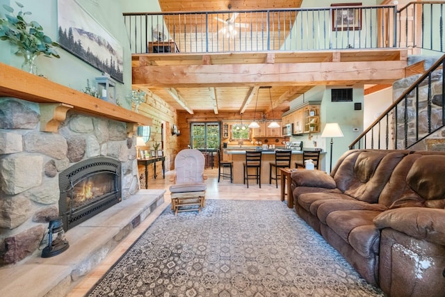 5618 N 725 E, Fremont, IN 46737 - living area featuring a stone fireplace, a high ceiling, light wood-type flooring, stairs, and a wood ceiling with exposed beams