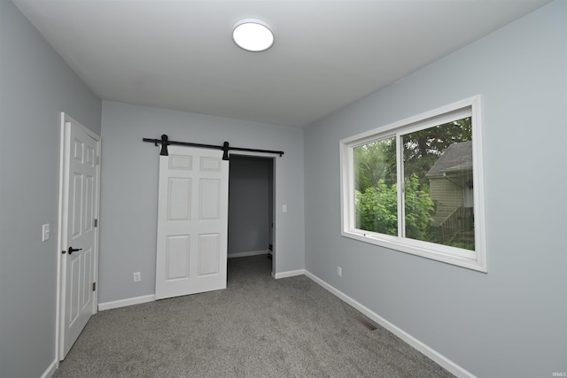 221 Park St, Laporte, IN 46350 - unfurnished bedroom with carpet flooring, a barn door, and a spacious closet