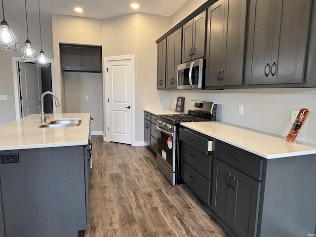 1544 Cananea Way, Fort Wayne, IN 46845 - kitchen featuring appliances with stainless steel finishes, dark wood-style flooring, an island with sink, pendant lighting, and light countertops