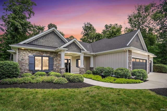 126 Tumbling Stone Ct, Fort Wayne, IN 46845 - craftsman-style house featuring stone siding, a garage, driveway, board and batten siding, and a lawn