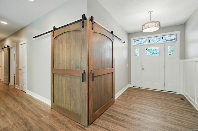 126 Tumbling Stone Ct, Fort Wayne, IN 46845 - foyer entrance featuring a barn door, wood finished floors, and recessed lighting