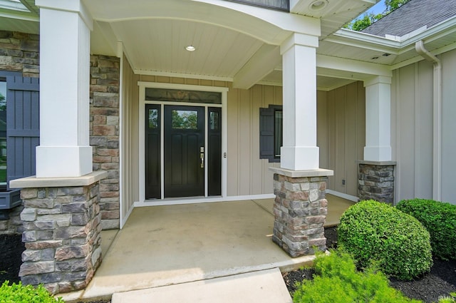126 Tumbling Stone Ct, Fort Wayne, IN 46845 - view of exterior entry with board and batten siding, stone siding, covered porch, and a shingled roof